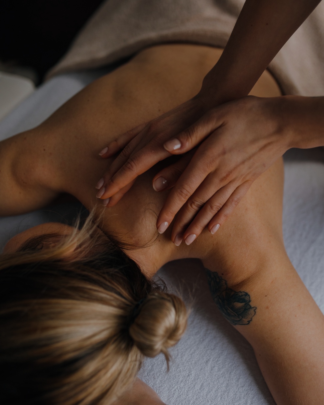 Therapist’s hands massaging a guest’s shoulders